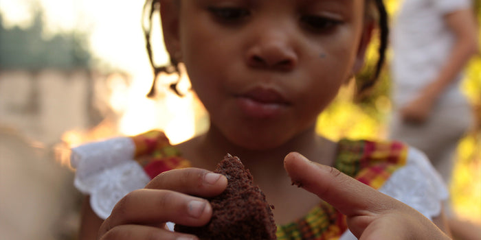 young girl eating a chocolate brownie