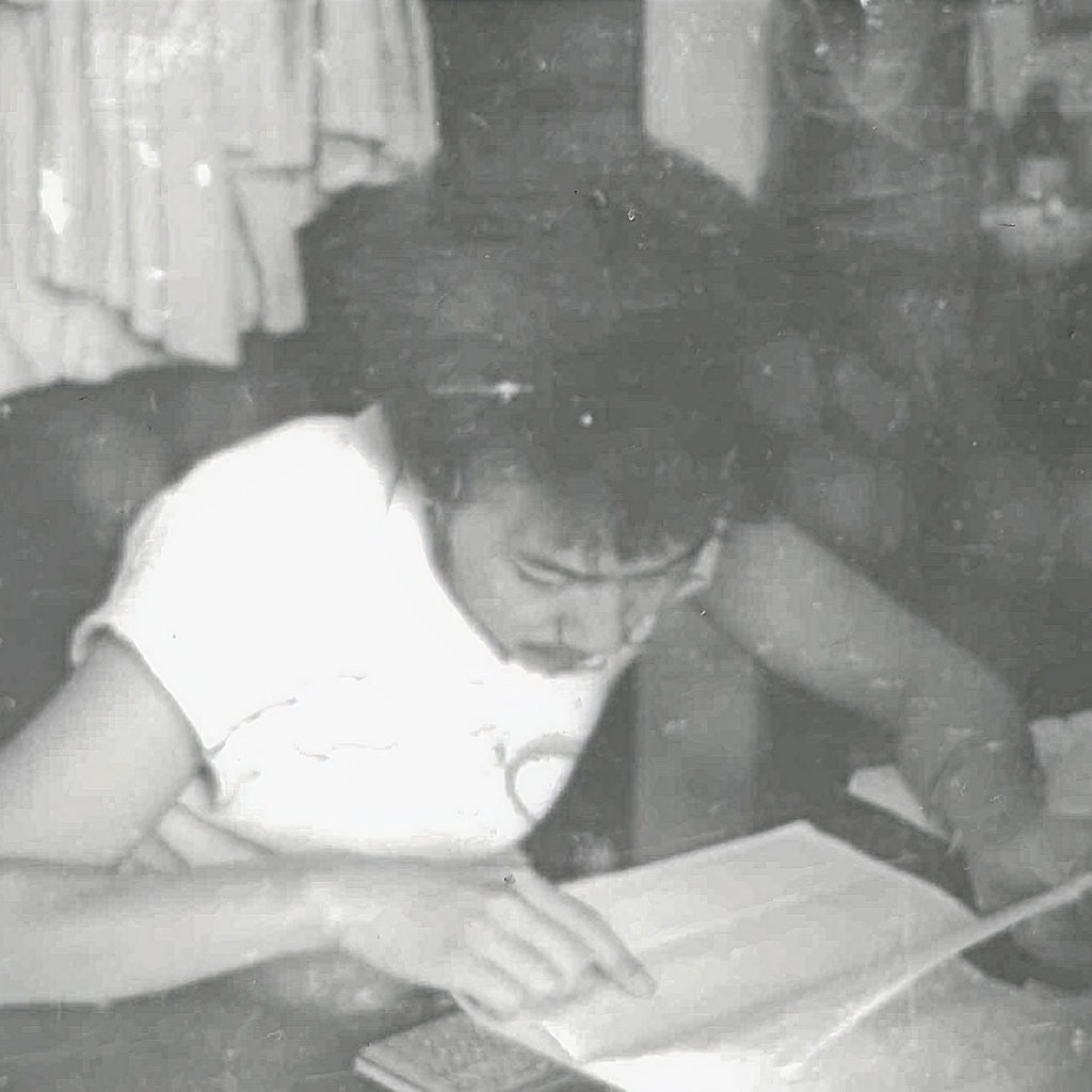 Young Dirty Labs co-founder Dr. Pete studying from a book in an old black and white photograph.