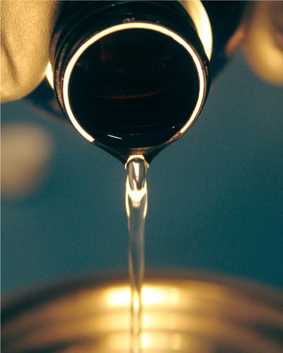 Oil pouring out of a bottle close up