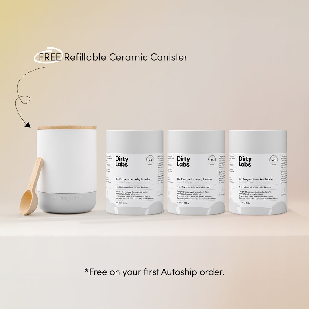 The Booster Trio Bundle + Canister features a ceramic canister with wooden spoon and three Dirty Labs Bio Enzyme Laundry Boosters. Text: FREE Refillable Ceramic Canister* with your first Autoship—ideal for your favorite laundry booster!.