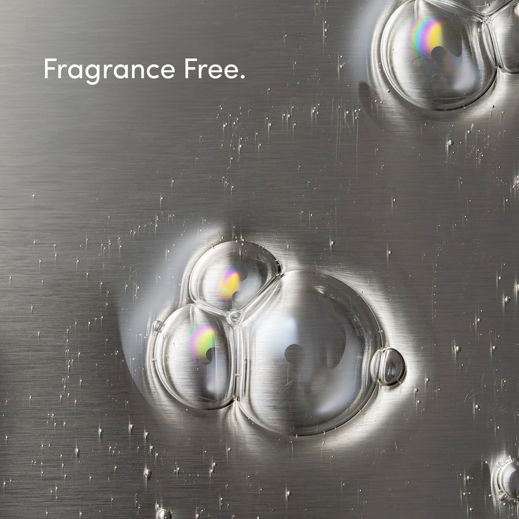 Clear soap bubbles with rainbow reflections rest on brushed metal. Fragrance Free. appears in white at the top left, highlighting our Free & Clear Bio Enzyme Liquid Dish Soap, a hyper-concentrated formula for clean dishes.