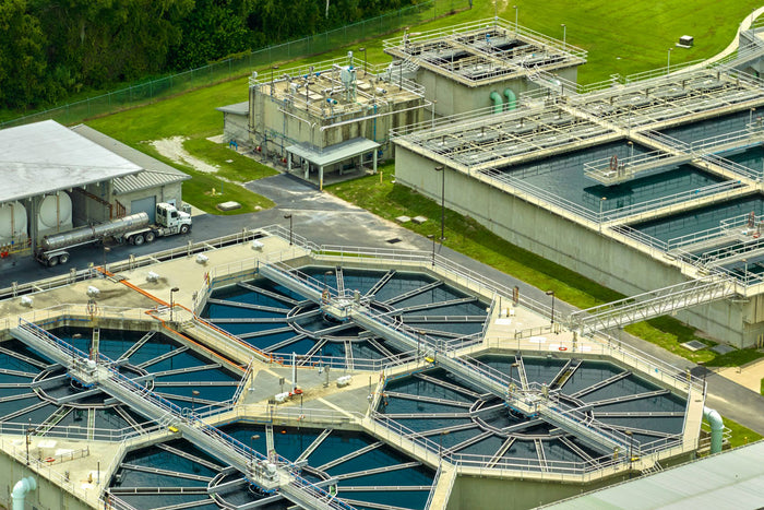 Wastewater treatment plant with water flowing through circular tanks.